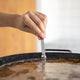 El Paeller Paella Broth Measurer - hand adjusting the measurer in the broth