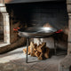 El Paeller Polished Carbon Steel Paella Pan - pan over a wood fire in a fireplace